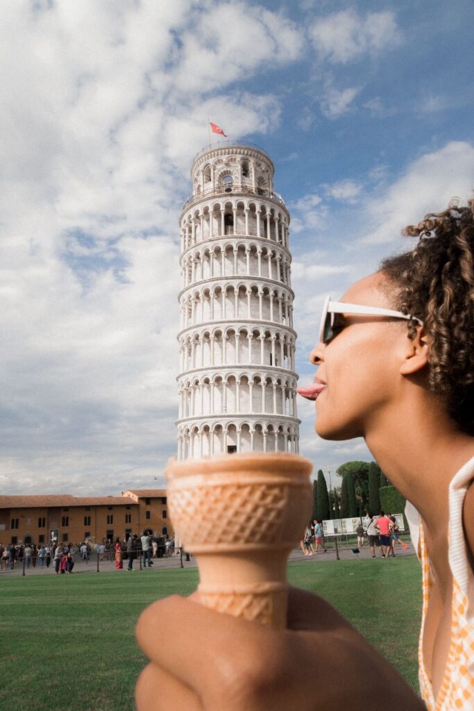 woman doing silly pose by the Tower of Pisa