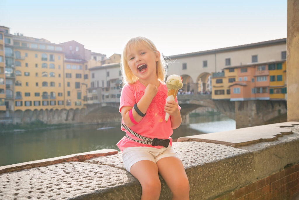 girl eating ice cream near Ponte Vecchio in Florence, Italy