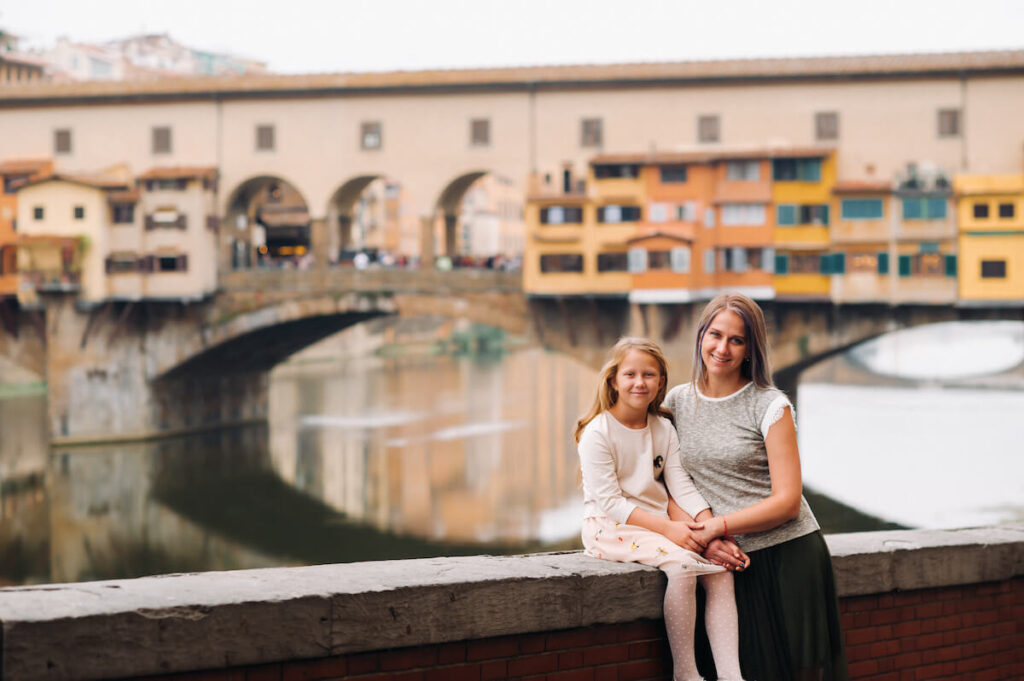 mother and daughter against the backdrop of the Ponte Vecchio bridge in Florence