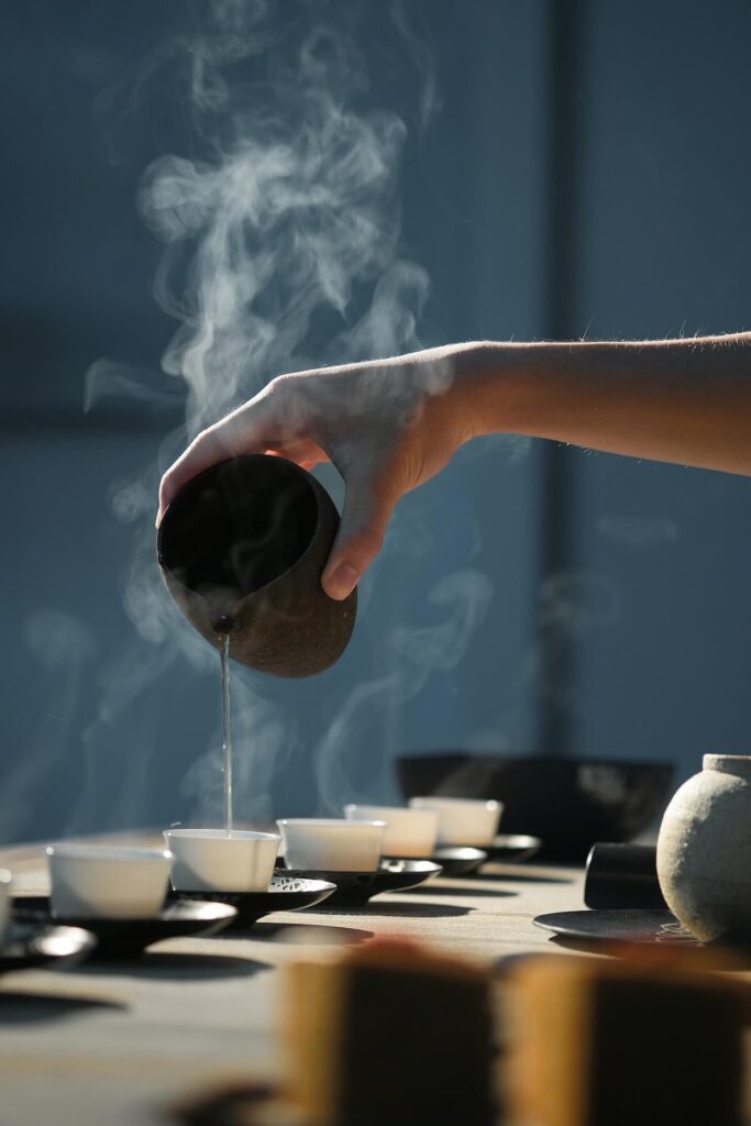hand pouring tea on cups