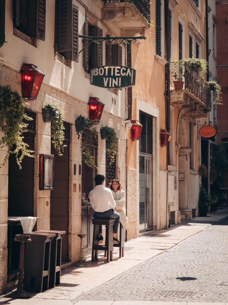 man and woman sitting outside bottega in Verona