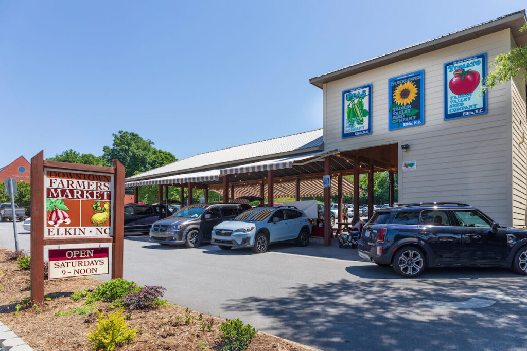 The Elkin downtown Farmers' Market, showing covered street sign, vendor area and parking lot