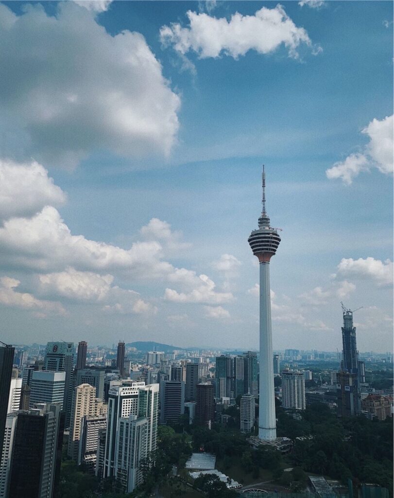 KL tower under white clouds and blue sky during daytime