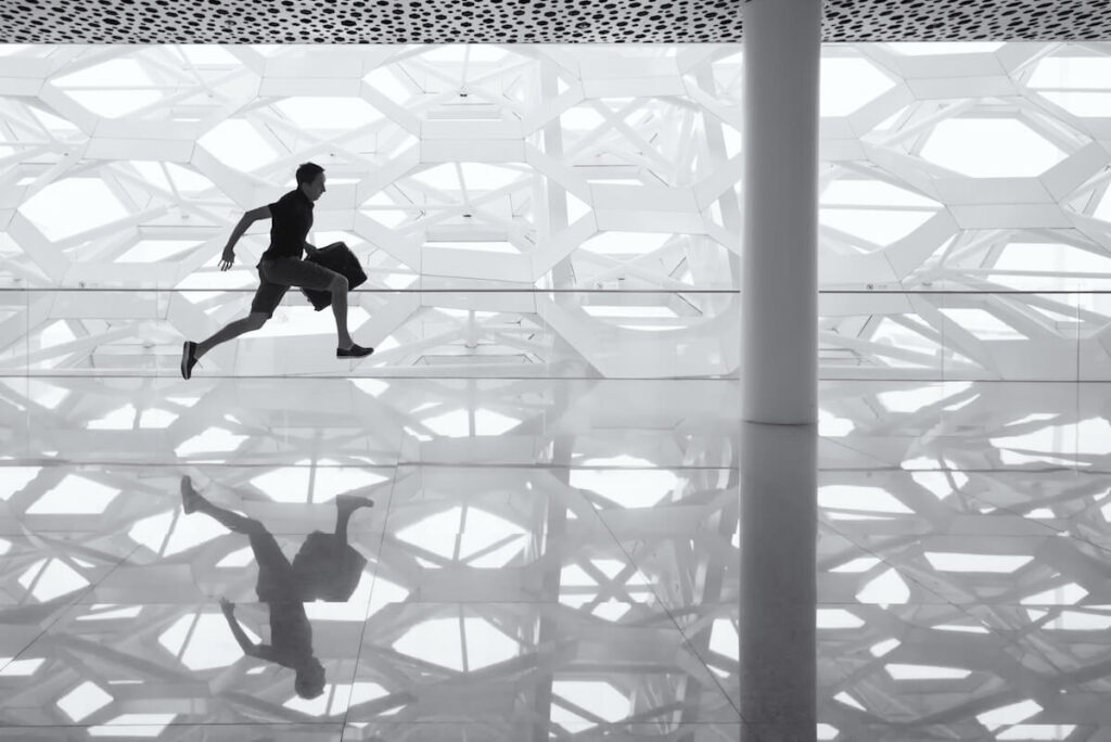 man holding handbag running in an airport