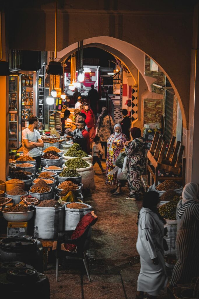 various items for sale and people in market in Meknes, Morocco