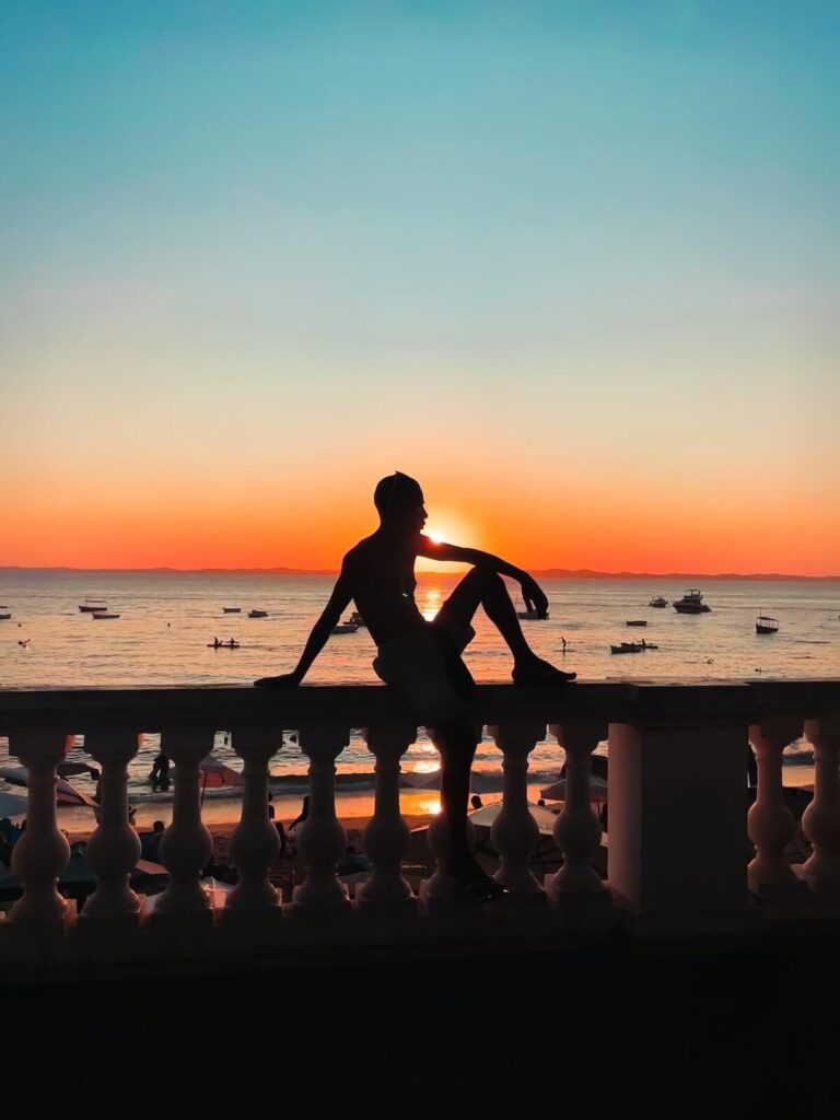man sitting on boardwalk balustrade in salvador