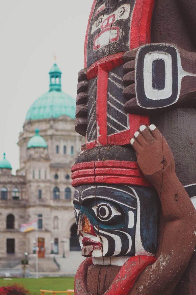 Totem pole carving against parliament