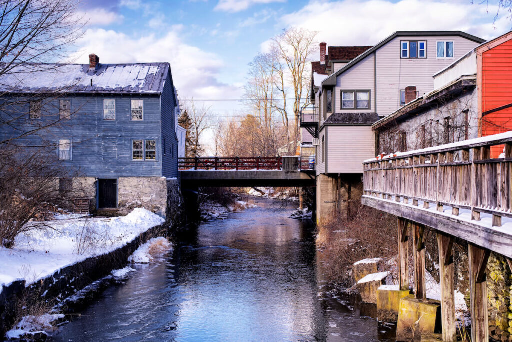 Old buildings lining the Williams river running through the village of West Stockbridge Massachusetts on a sunny winter day