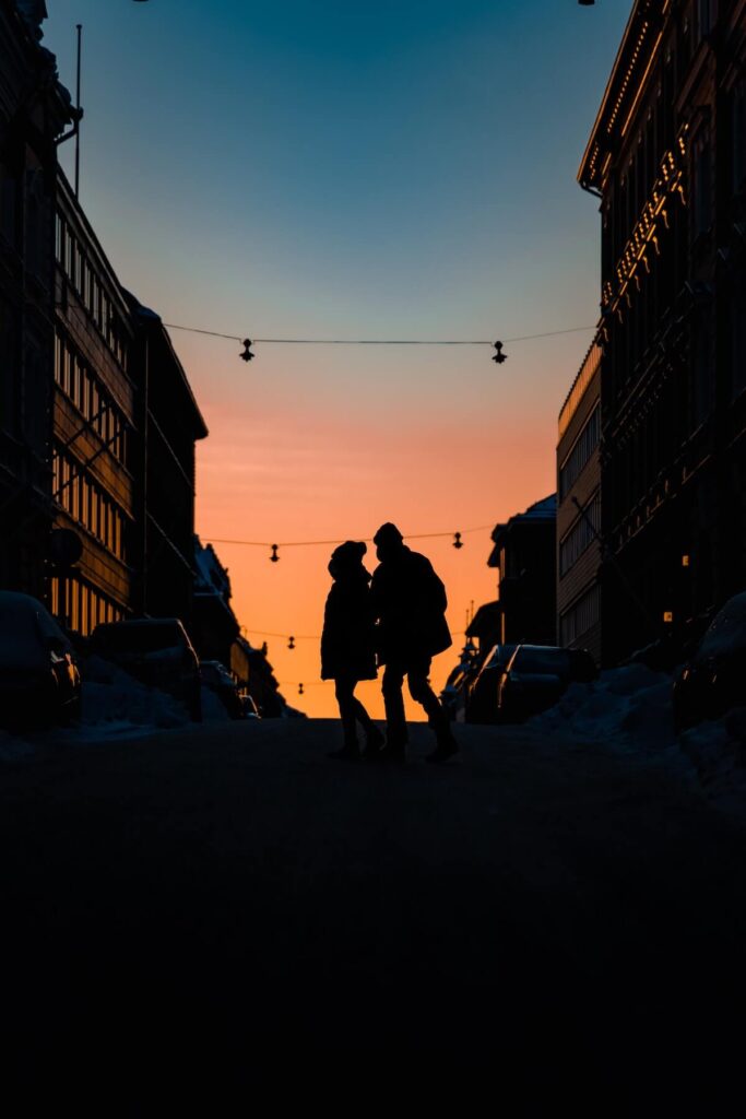 People cross street at sunset