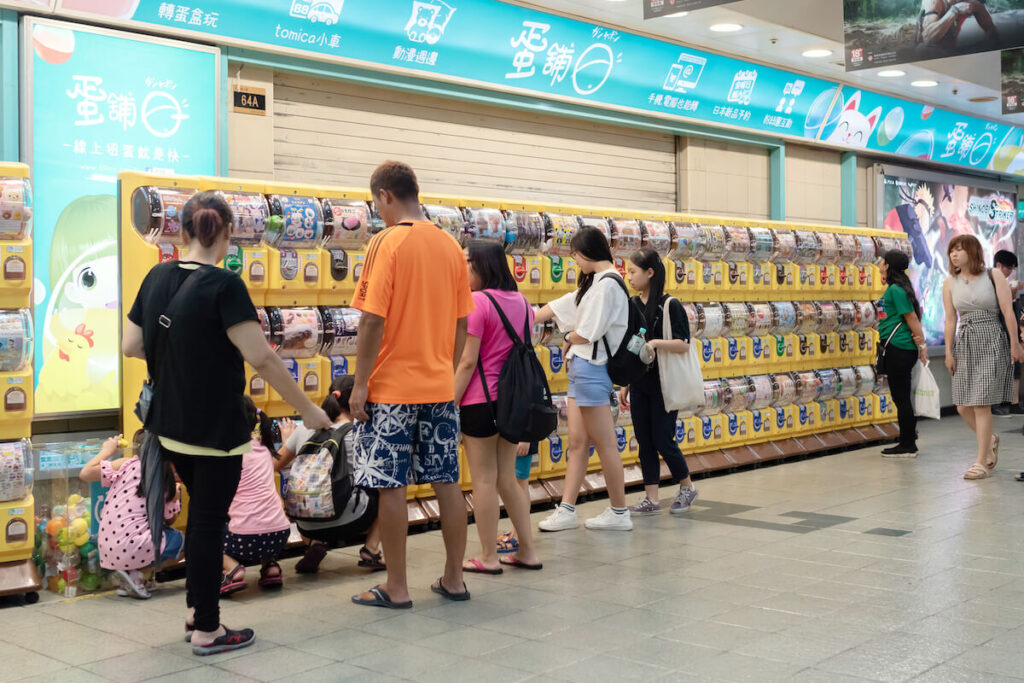 Customers browsing through anime and manga merch display at the underground Taipei City Mall