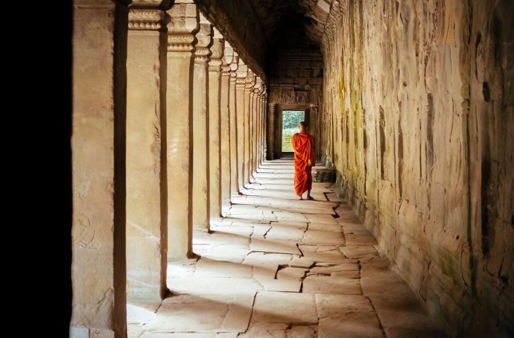 monk standing in the middle of a corridor