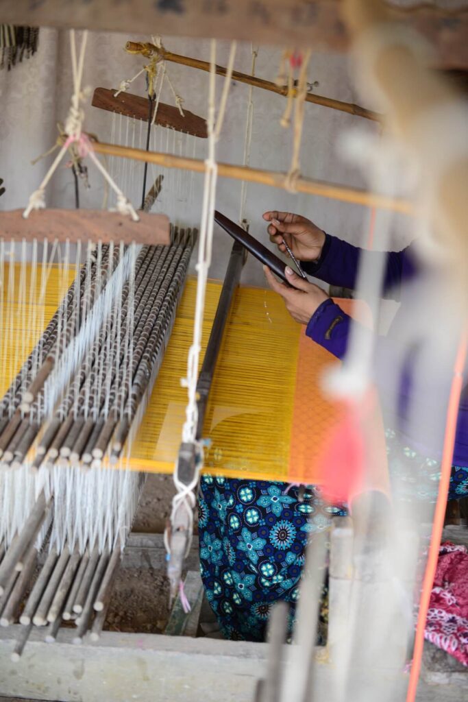 Person weaving yellow silk