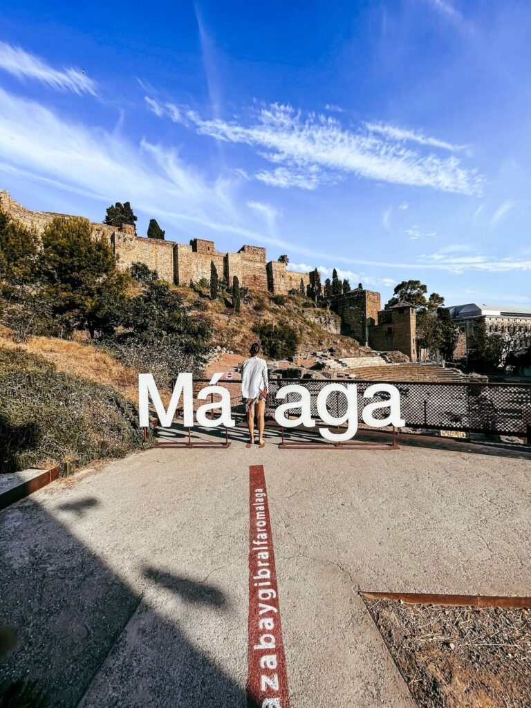 woman standing near Malaga sign