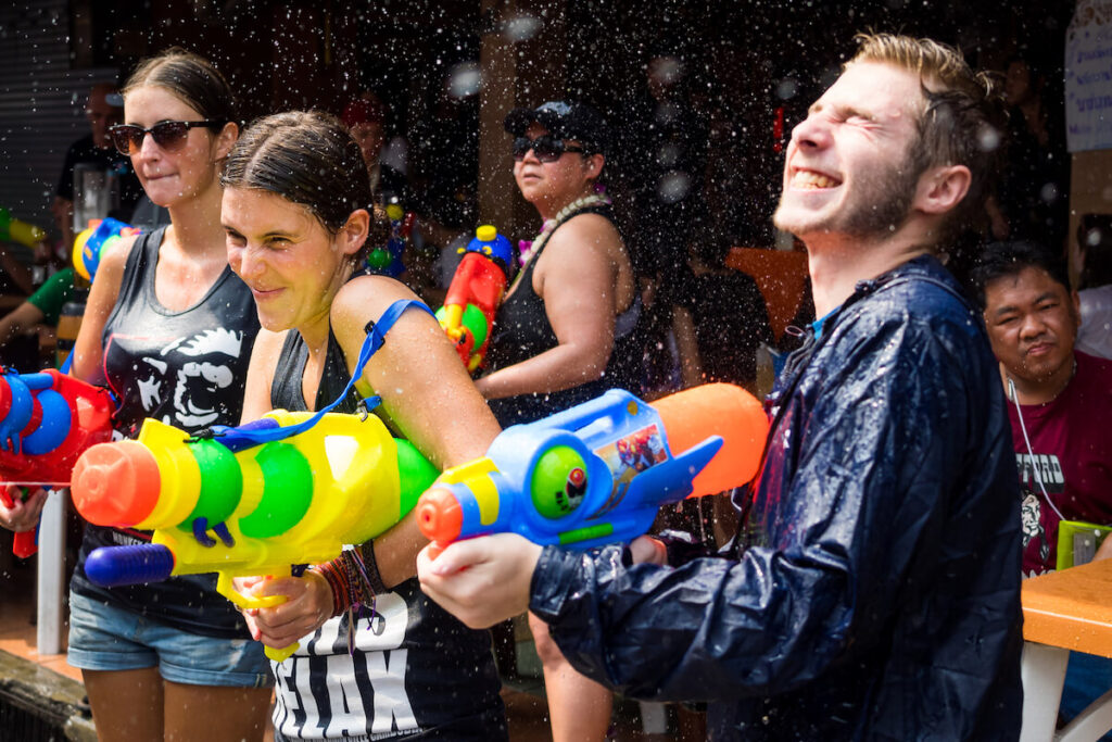 tourists shooting with water guns and having fun during Songkran, the traditional Thai New Year, on Khao San Road in Bangkok