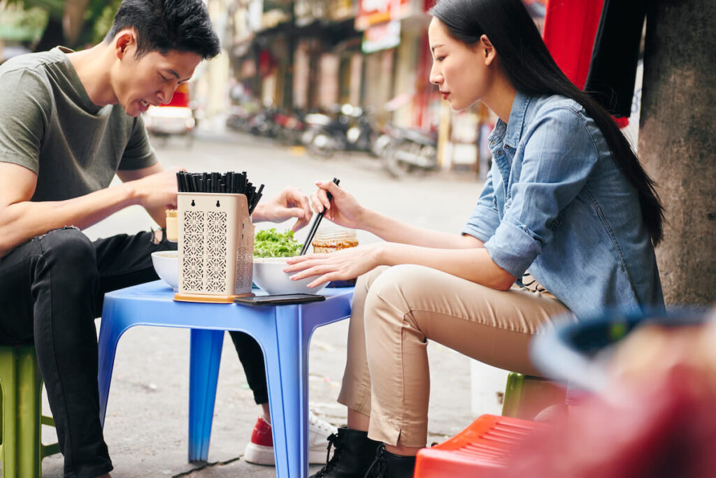 couple eating at a roadside restaurant in Hanoi