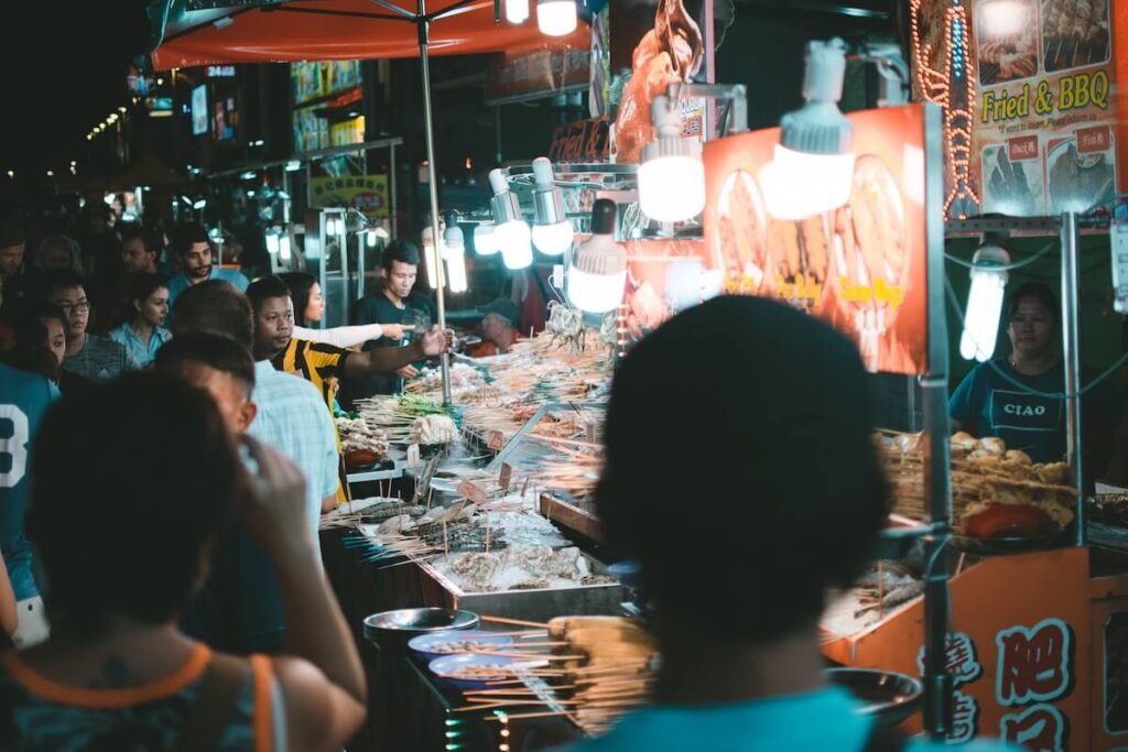 people standing near food stall in Jalan Alor