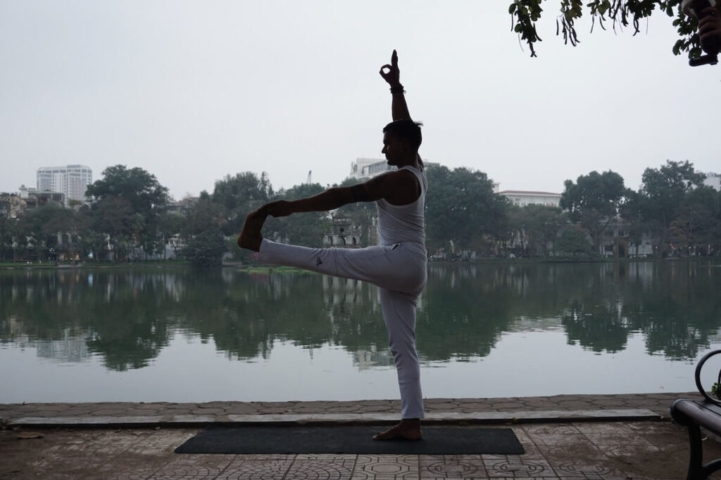 man doing yoga by the Hoan Kiem Lake