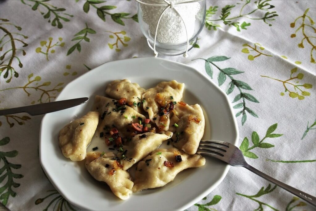 Dumplings with toppings on white plate tablecloth