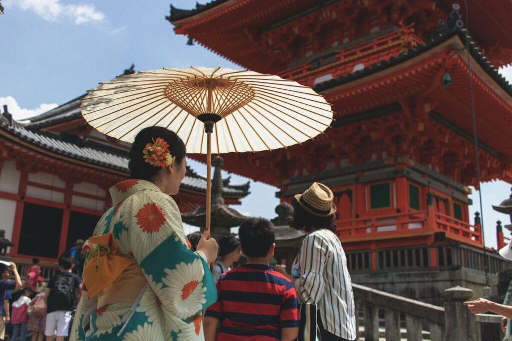 woman holding umbrella while visiting Kiyomizu-dera Temple in Kyoto, Japan