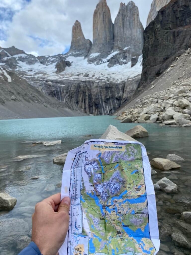 person holding map with Torres del Paine in the background