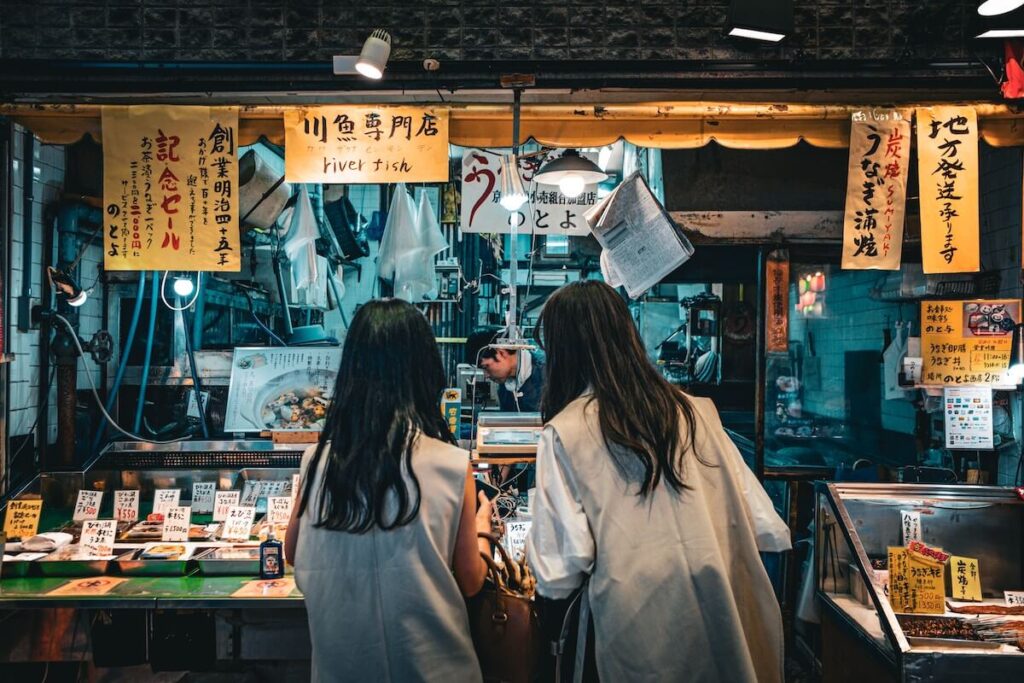 Women discussing which sushi to purchase at the Nishiki Market