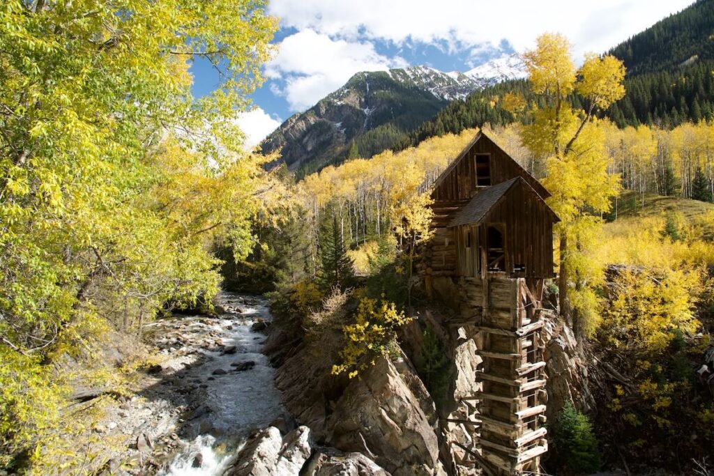 old mill along mountain creek in autumn