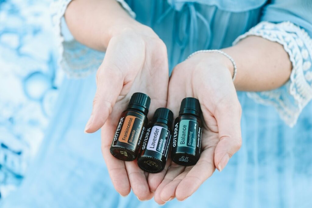 woman holding three bottles of essential oils