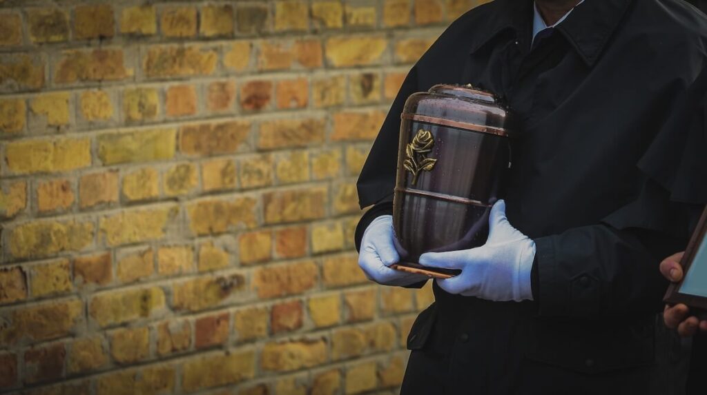funeral director bringing urn with ashes