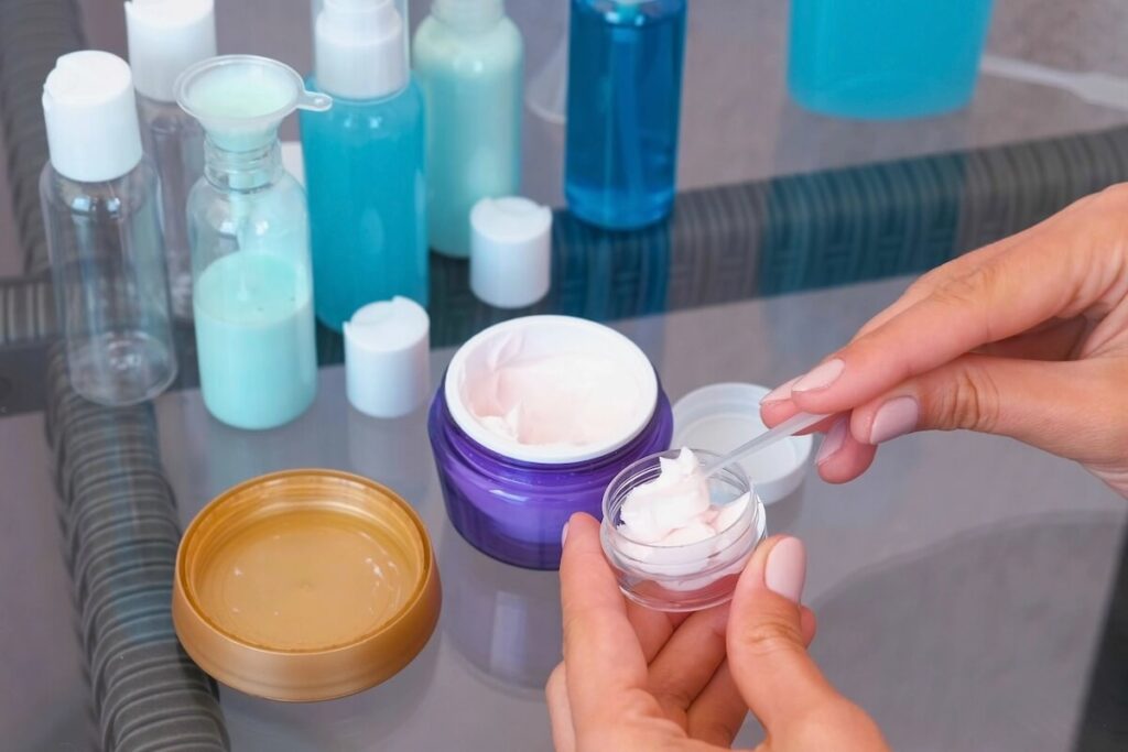 woman transferring cream from big to small container