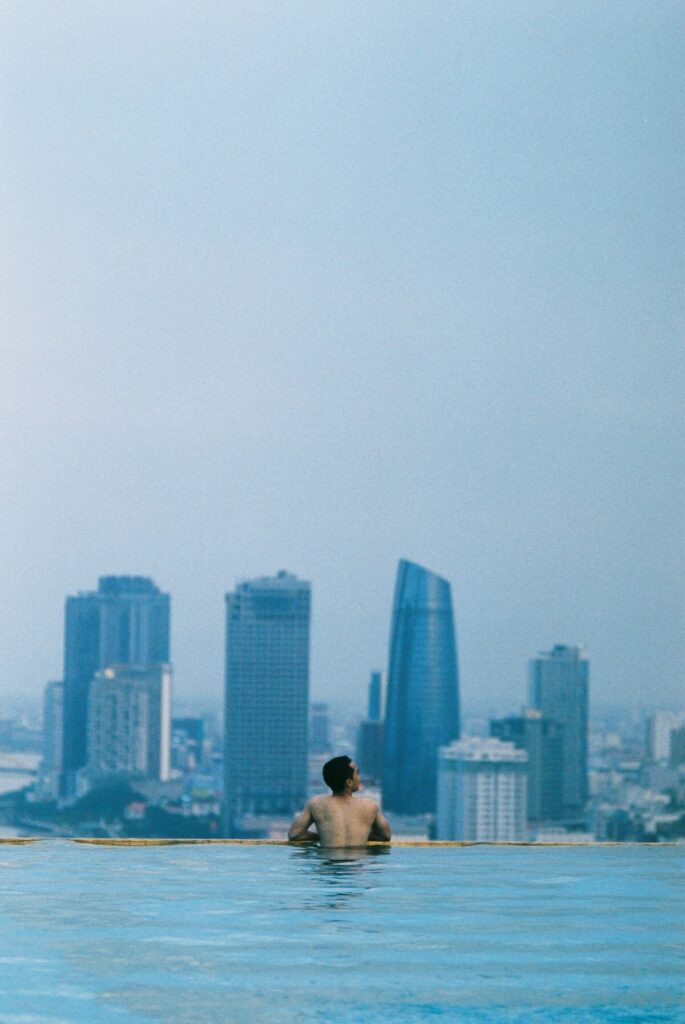 man lounging at rooftop pool of hotel in Da Nang