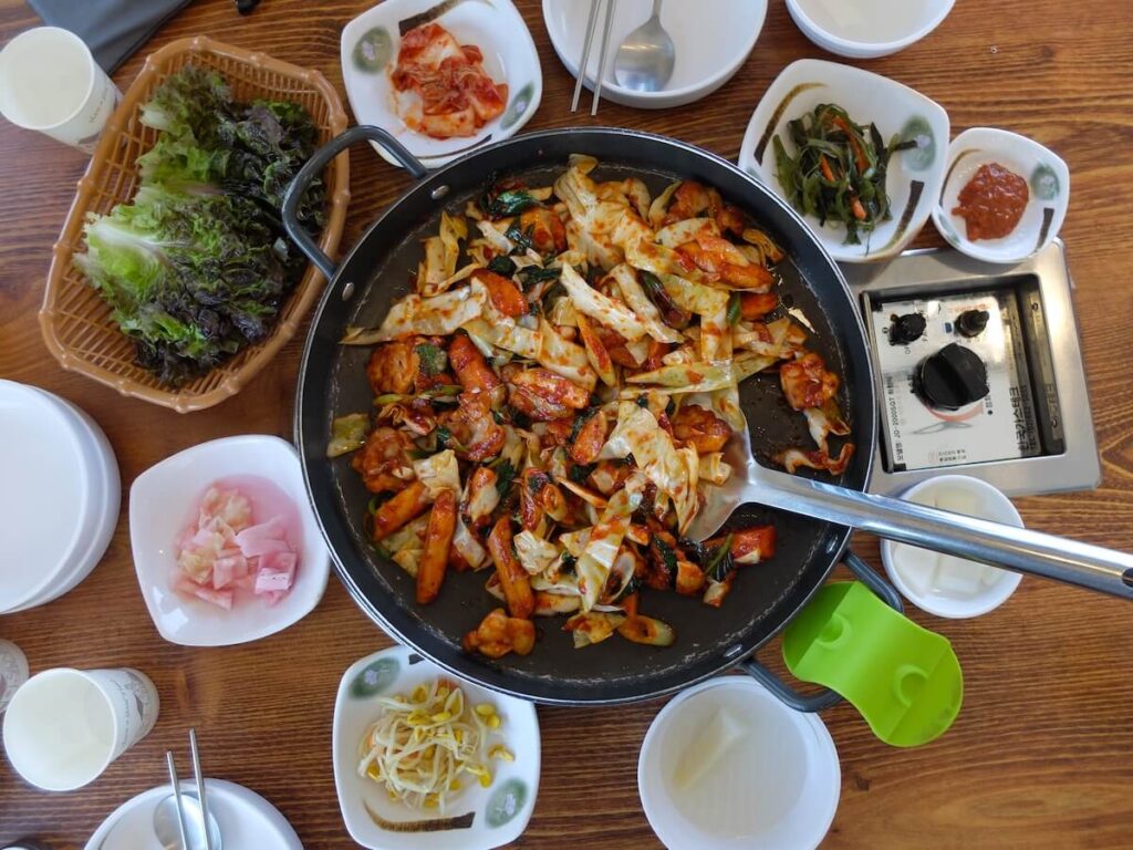 A pan of dakgalbi and side dishes served at Alisu in Gapyeong