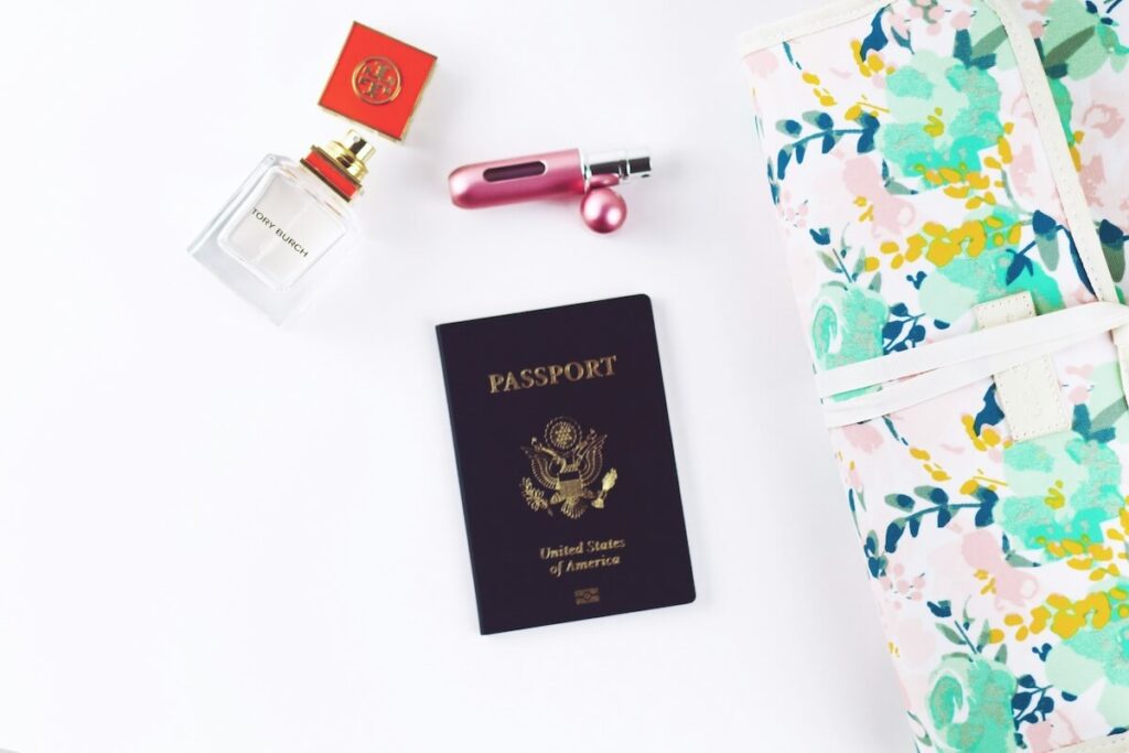 flatlay of perfume, passport, and other items