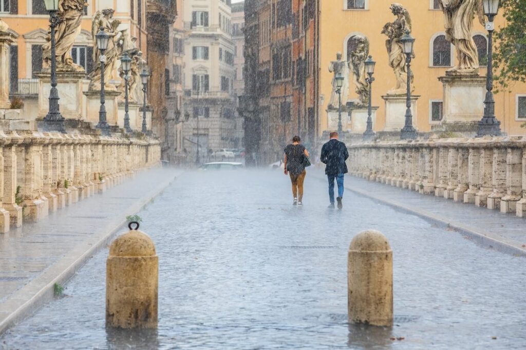 two people walking in the rain in Rome, Italy
