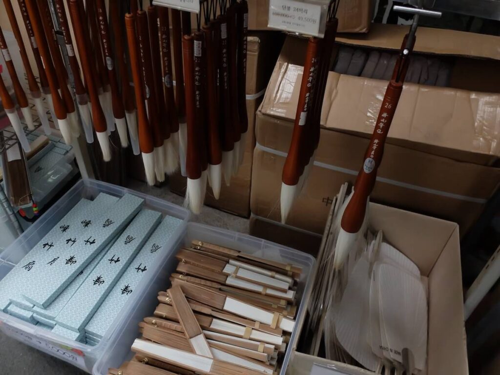 calligraphy brushes, hand fans, and other souvenirs for sale in a store in Insadong, Seoul
