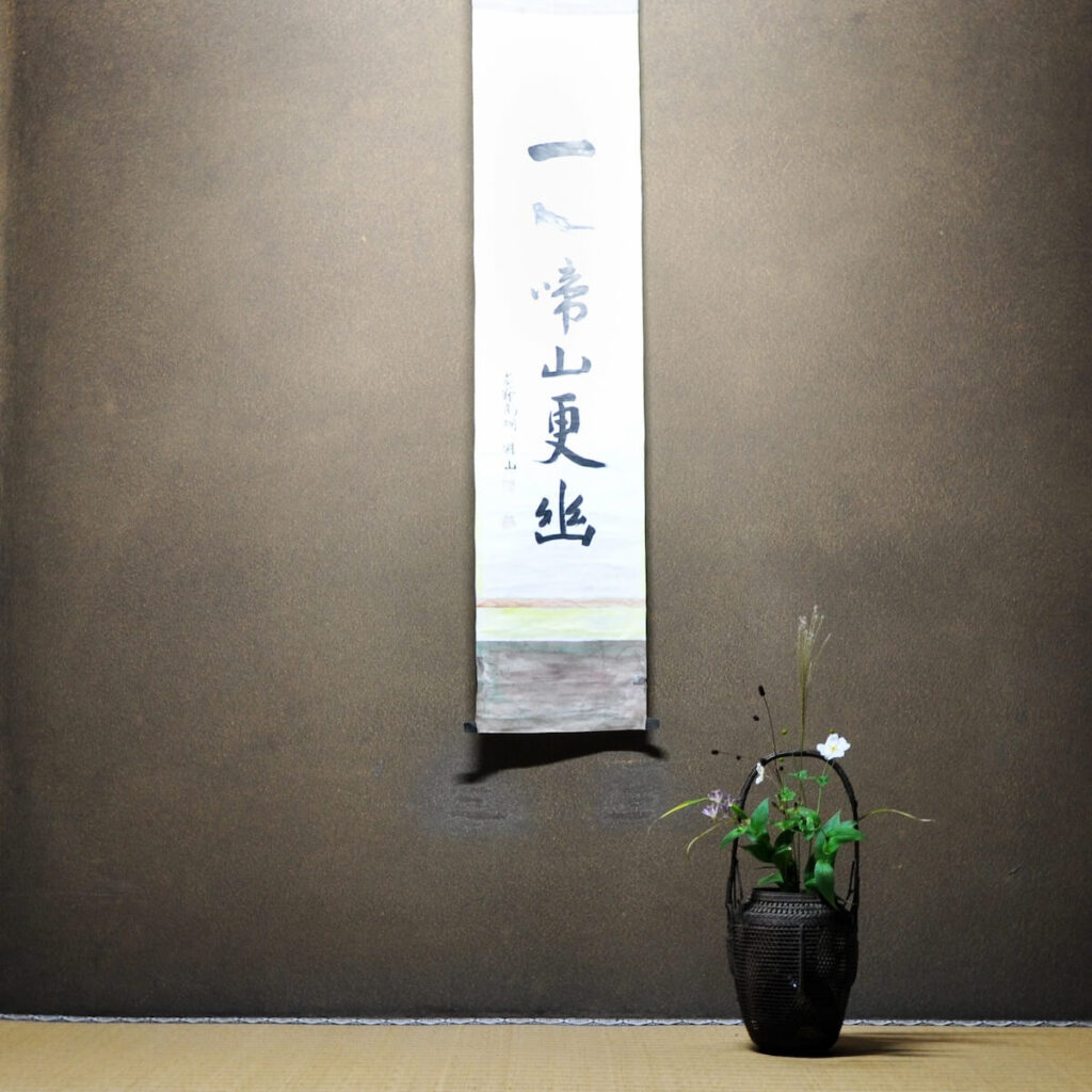 ikebana near Japanese hanging scroll