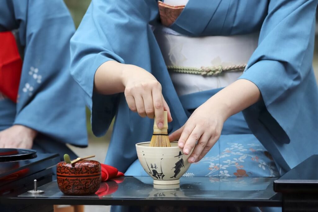 woman whisking matcha on bowl