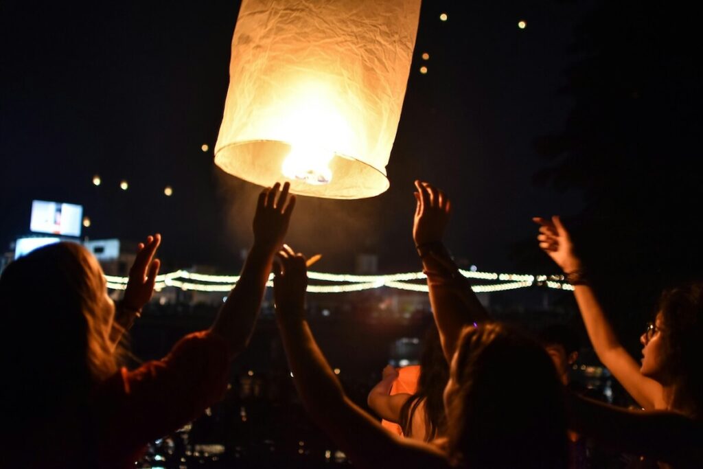 people raising lantern during Yi Peng festival in Chiang Mai