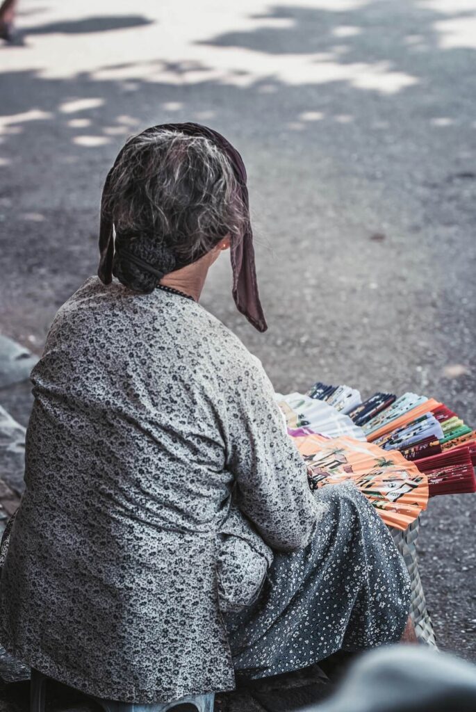 old woman selling hand fans
