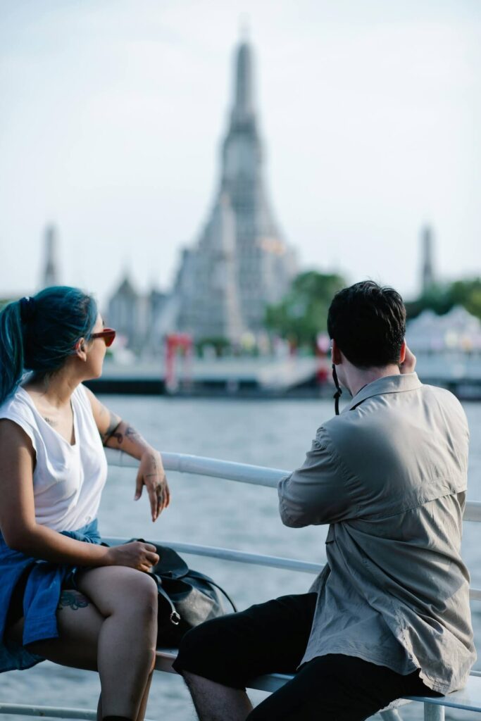 couple looking at Wat Arun aboard a boat