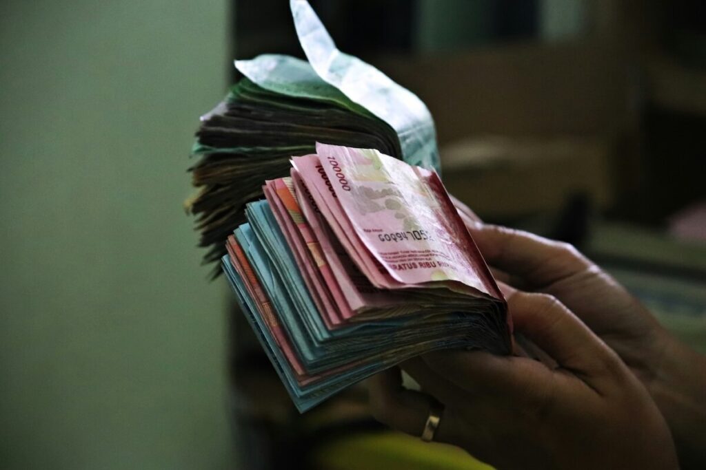 man counting Rupiah bills