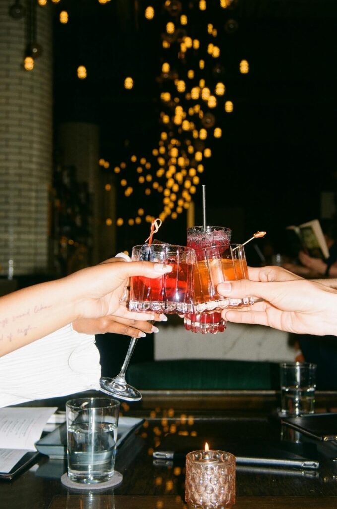 people toasting drinks at a bar