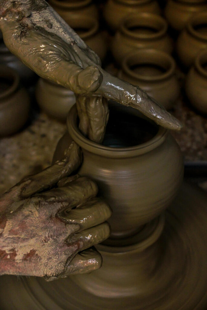 man molding a clay pot