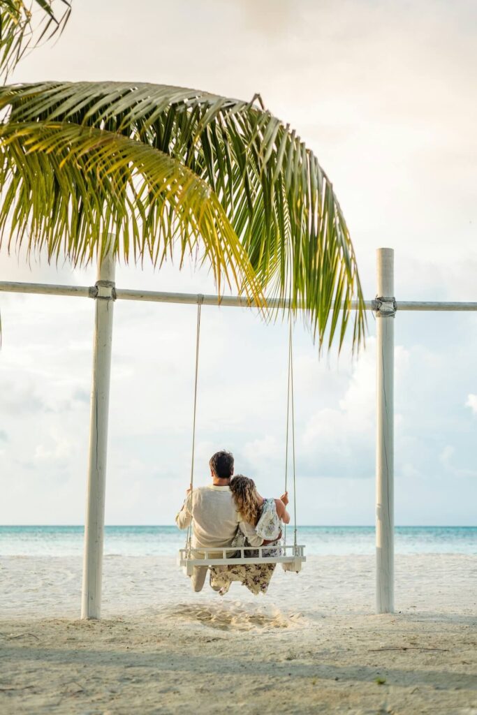 couple on a swing on a beach in the Maldives
