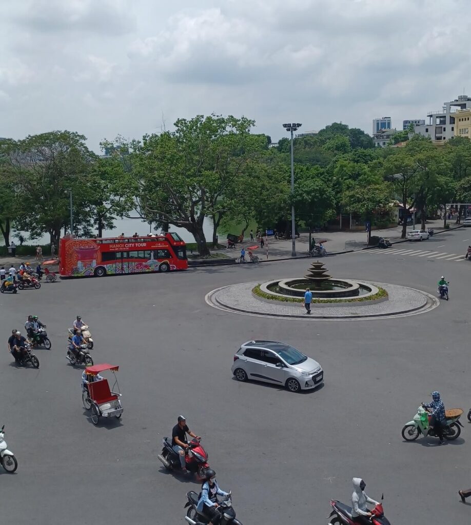 Hanoi city tour bus parked near Hoan Kiem Lake at the Dong Kinh Nghia Thuc Square