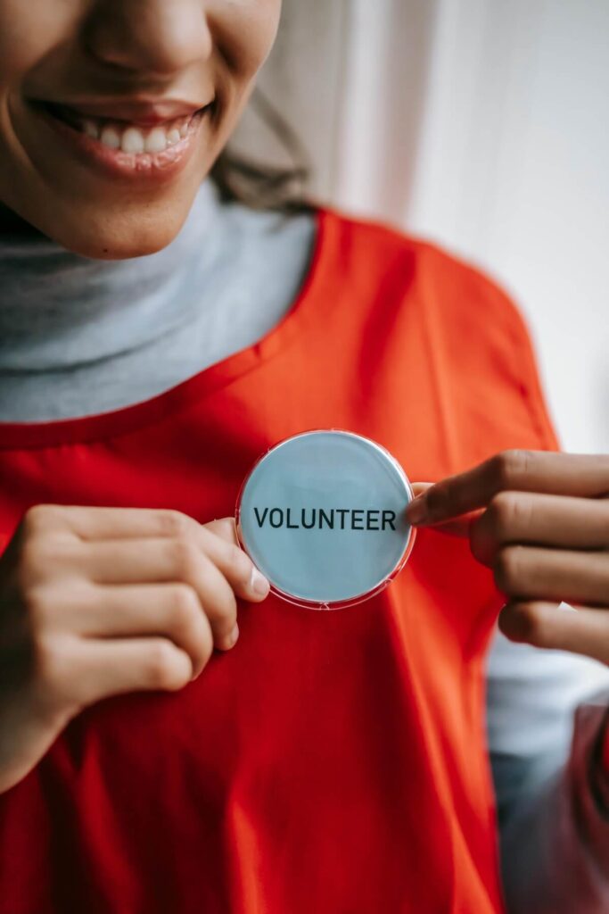 smiling woman with volunteer badge