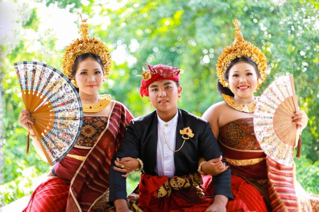 people wearing traditional Indonesian costume, women holding handfans