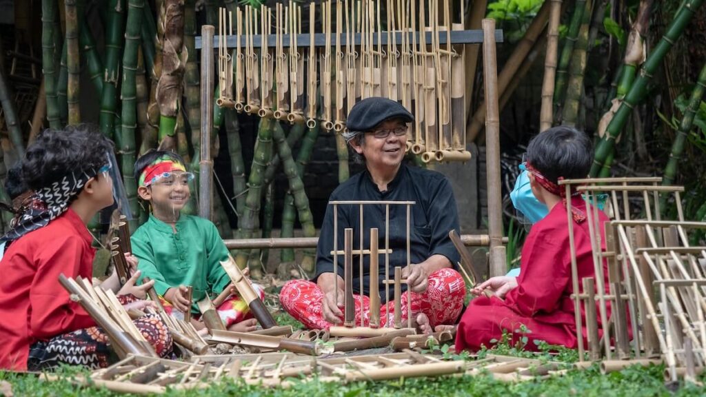 man and students making angklung, an Indonesian musical instrument