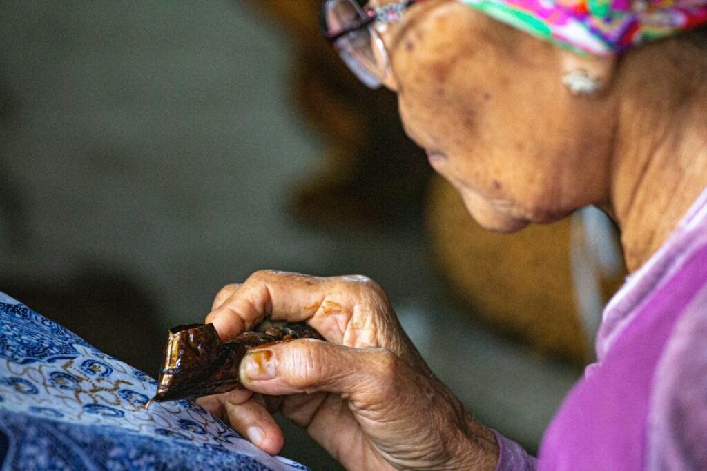 woman making batik design by hand
