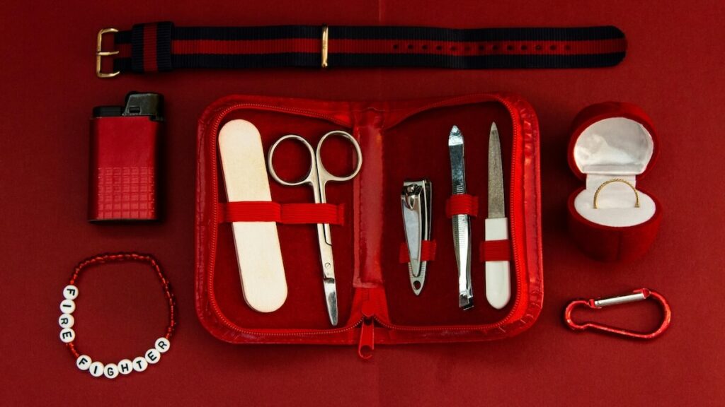 red themed flat lay of manicure set and other items