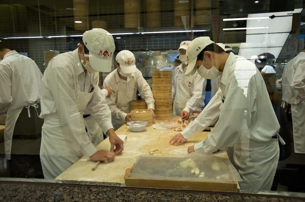 making xiao long bao inside glass box in Din Tai Fung